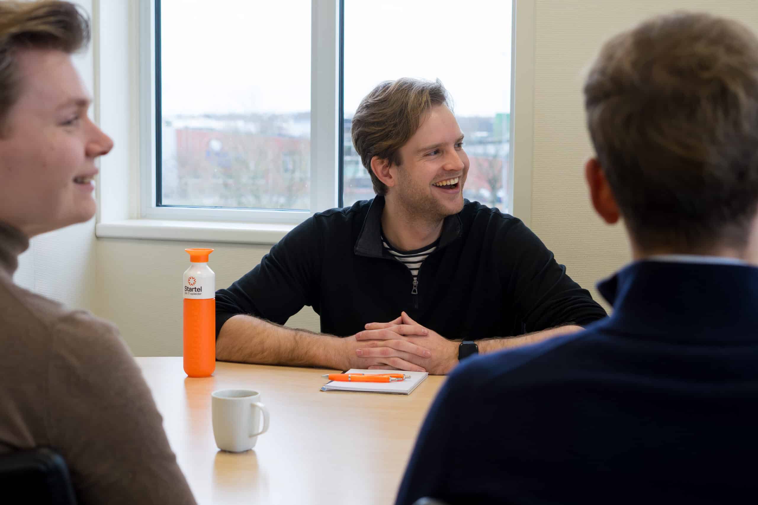 Een medewerker van Startel zit aan tafel.