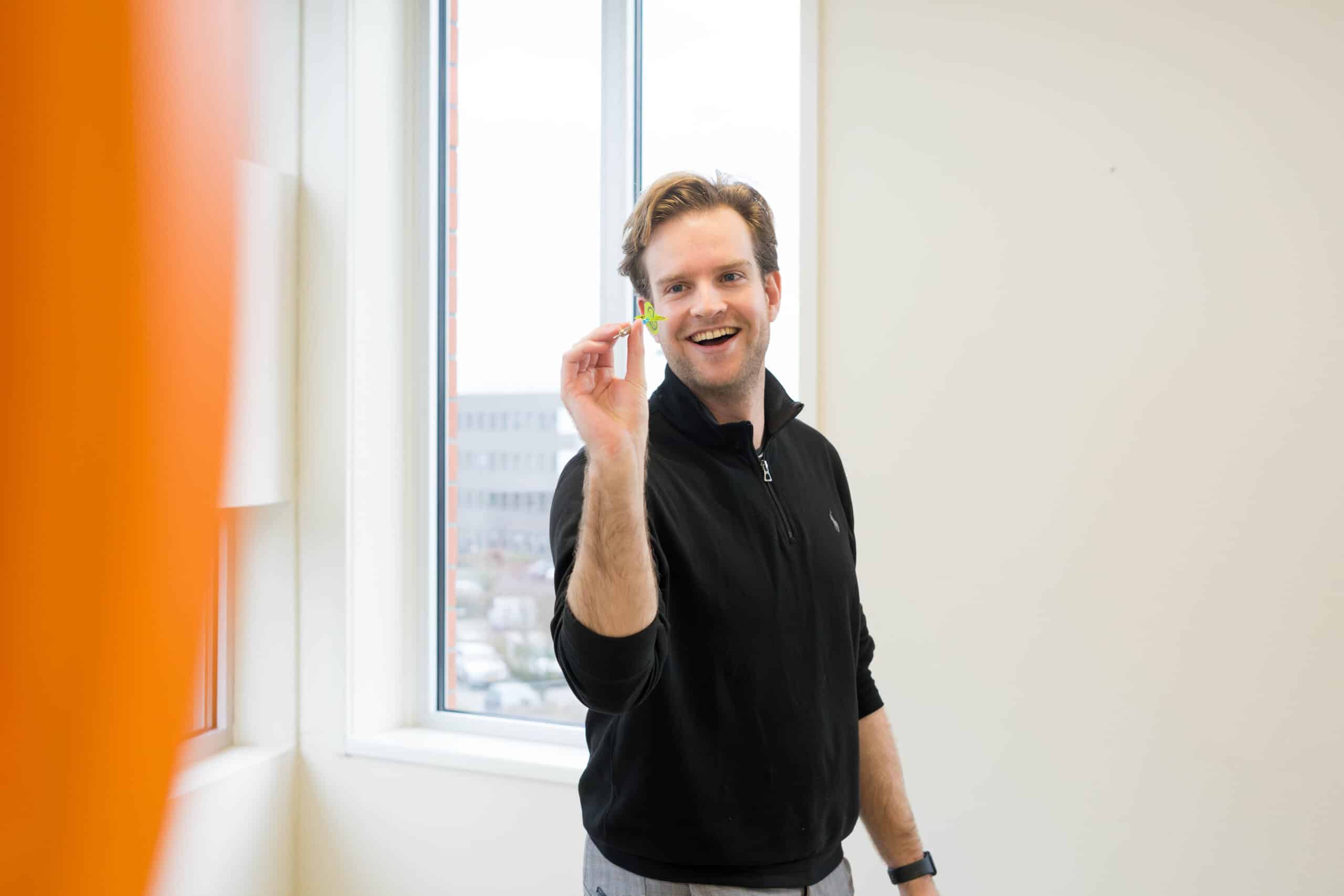 Een medewerker van Startel (Pieter Fokkema) gooit een dartpijl.