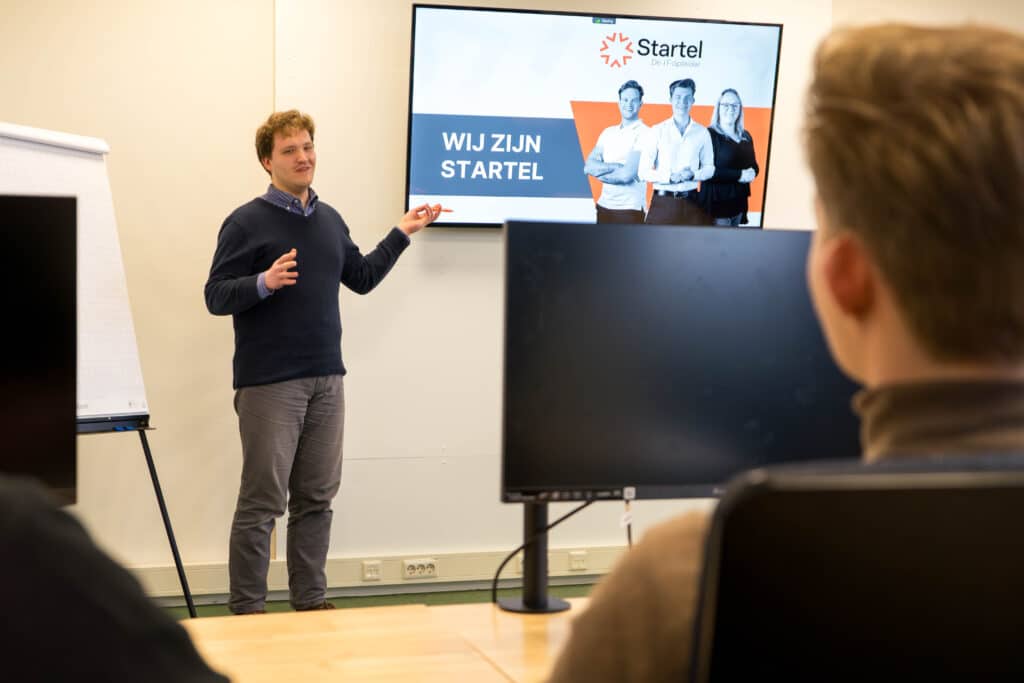 Een medewerker van Startel (Johannes van Oosterom) reageert op iemand in de klas.