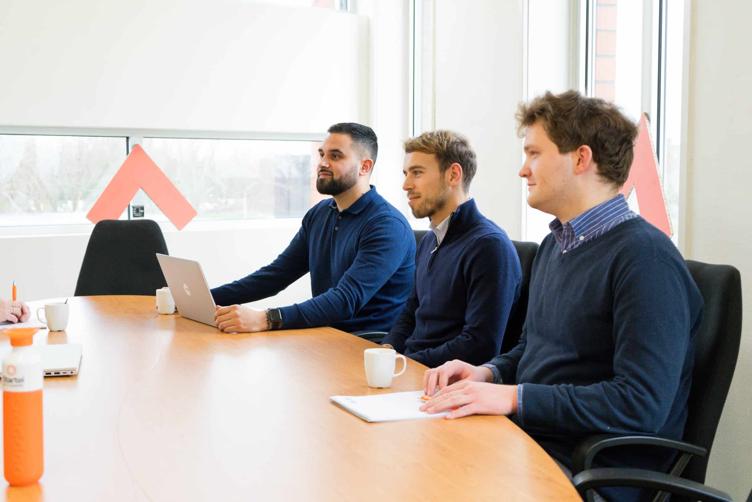 Twee medewerkers van Startel en een medewerker van Yelgo luisteren naar een verhaal.